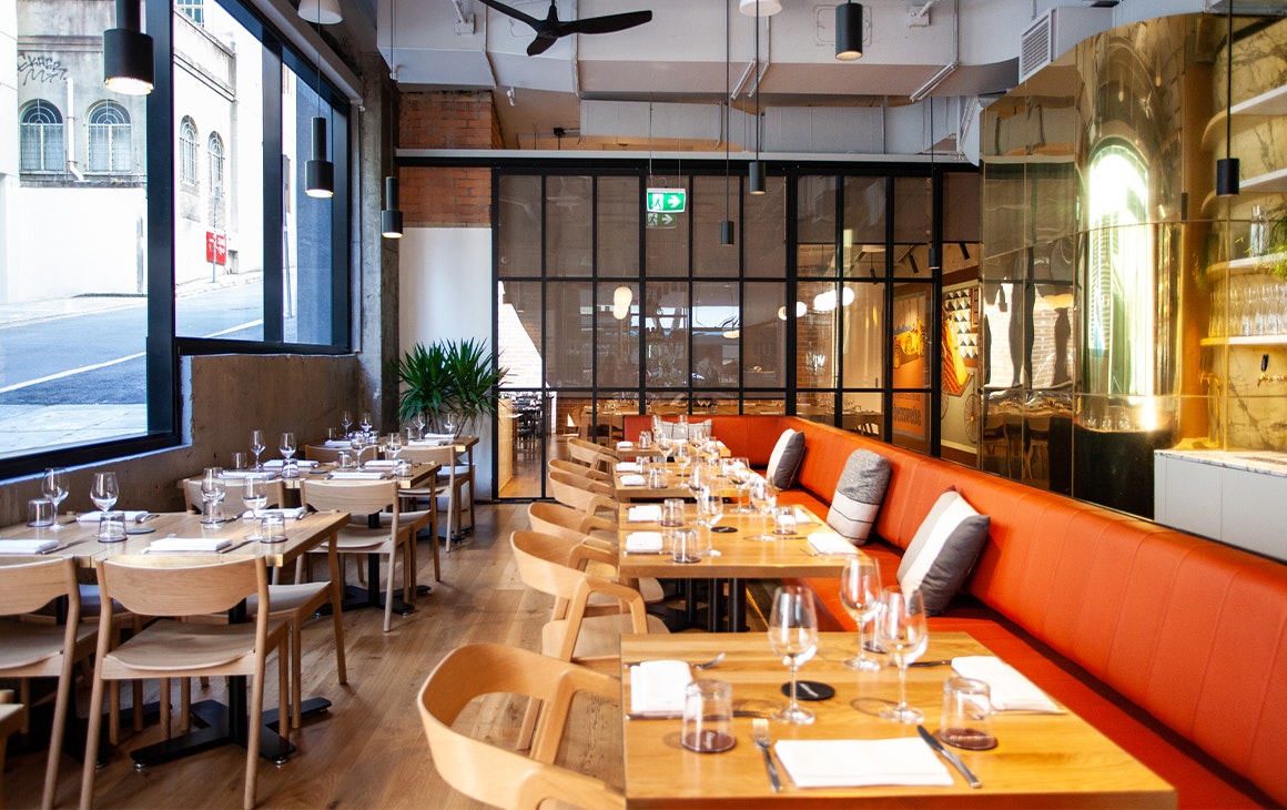 the interior of a restaurant with red bench seating